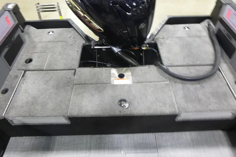 Slide: The Image of 2025 Alumacraft Trophy 205X Sport boat interior with motor and carpeted deck. - 12