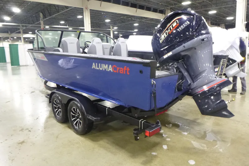 Slide: The Image of 2025 Alumacraft Trophy 205X Sport boat on trailer, displayed indoors. - 3