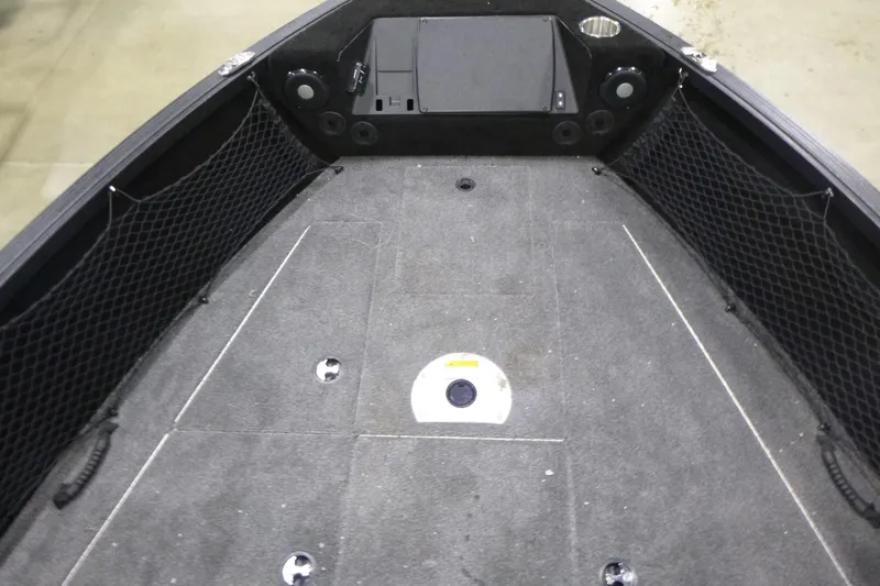 Slide: The Image of 2025 Alumacraft Trophy 205X Sport boat interior with carpeted deck and storage nets. - 6