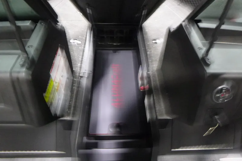 Slide: The Image of 2025 Alumacraft Trophy 205X Sport boat interior with storage compartments and control panel. - 7