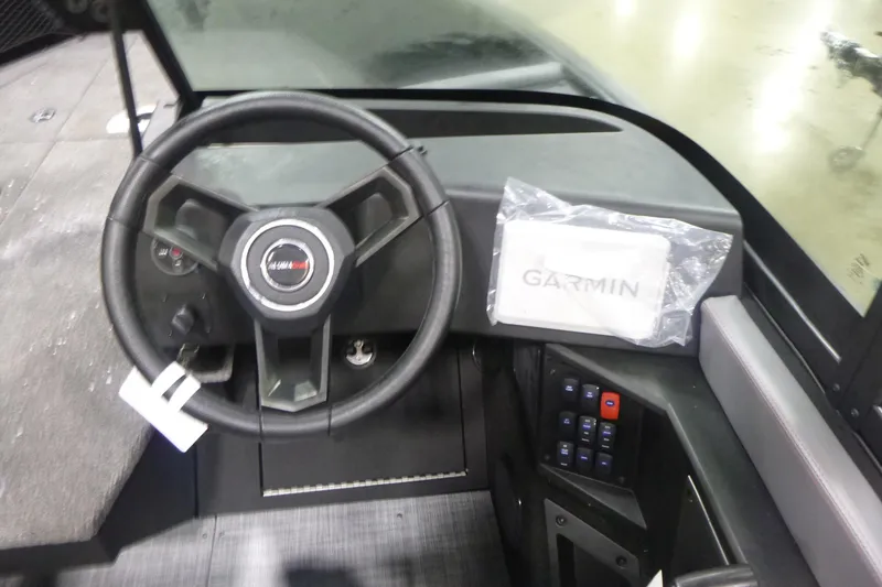 Slide: The Image of 2025 Alumacraft Trophy 205X Sport dashboard with steering wheel and Garmin navigation system. - 9