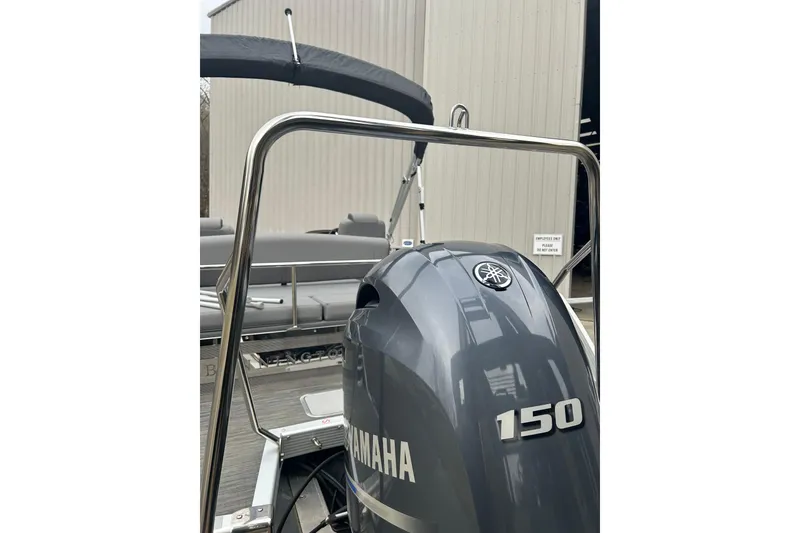 Slide: The Image of 2023 Bennington L 23 Swingback with Yamaha 150 outboard motor, docked near a building. - 3