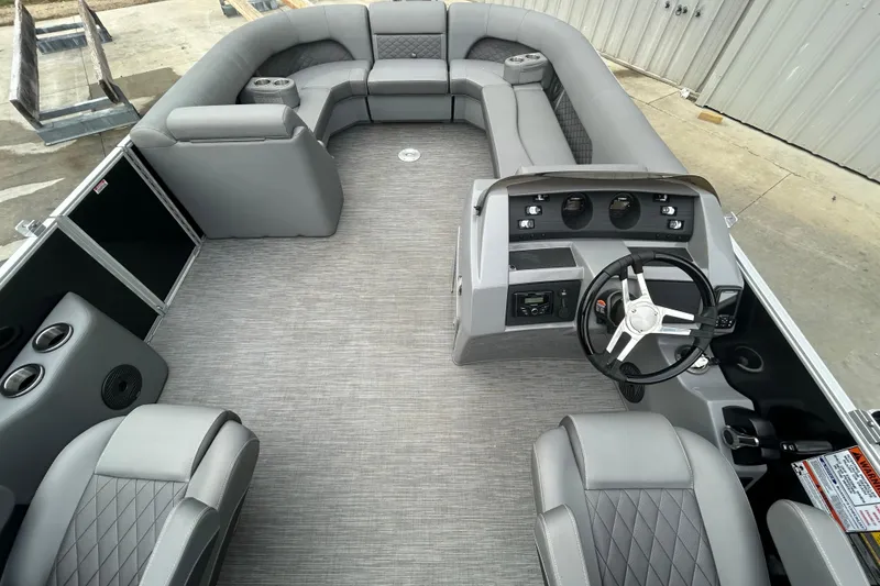 Slide: The Image of 2023 Bennington L 23 Swingback pontoon boat interior with gray seating and modern dashboard. - 4