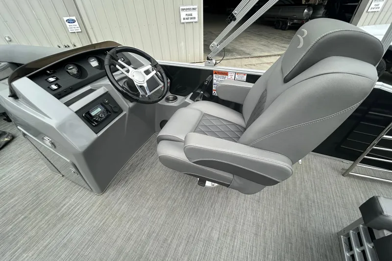 Slide: The Image of 2023 Bennington L 23 Swingback boat interior with steering wheel and captain's chair. - 8