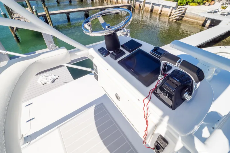 Slide: The Image of Control panel of a 2015 Intrepid 400 Center Console boat docked by the water. - 103