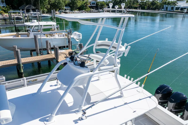 Slide: The Image of 2015 Intrepid 400 Center Console boat docked, featuring fishing rods and a clear blue water backdrop. - 15