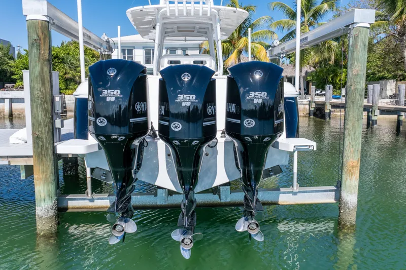 Slide: The Image of 2015 Intrepid 400 Center Console with triple Yamaha 350 engines docked by palm trees. - 5