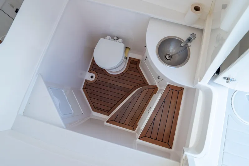 Slide: The Image of 2015 Intrepid 400 Center Console bathroom with wooden flooring and compact sink. - 7