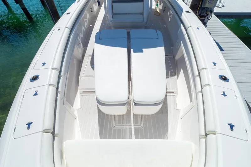Slide: The Image of 2015 Intrepid 400 Center Console boat with white seating and deck, docked by clear water. - 97