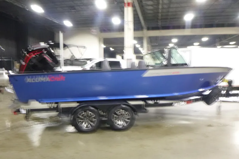 Slide: The Image of 2026 Alumacraft Competitor 205 Sport boat on display indoors. - 1