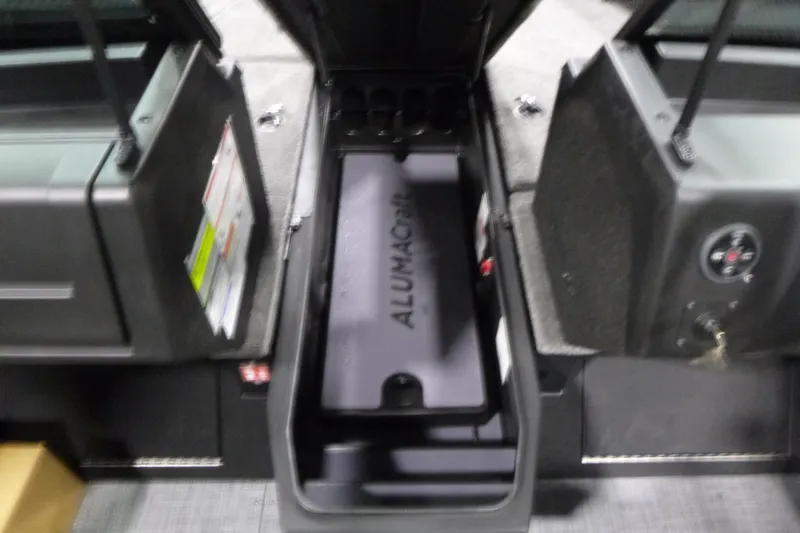 Slide: The Image of 2026 Alumacraft Competitor 205 Sport interior storage compartment with open hatches. - 11