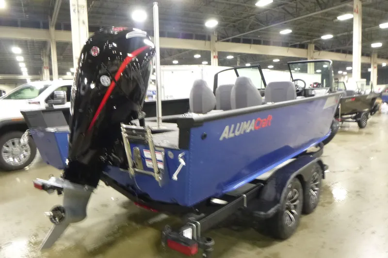 Slide: The Image of 2026 Alumacraft Competitor 205 Sport boat on trailer, displayed indoors. - 2