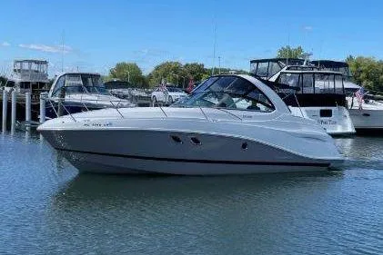 The Image of 2017 Rinker EX 320 boat docked in a marina under clear blue skies. - 0
