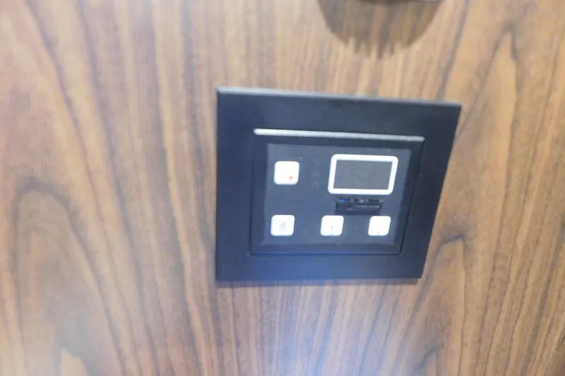 Slide: The Image of Control panel on 2017 Rinker EX 320 boat, mounted on wood paneling. - 100