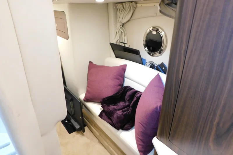 Slide: The Image of Interior of 2017 Rinker EX 320 boat with white seating and purple cushions. - 101
