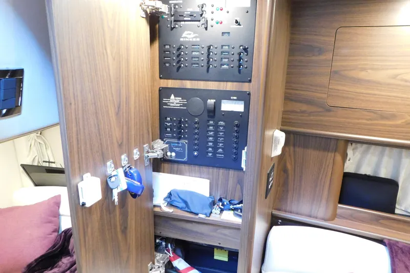 Slide: The Image of 2017 Rinker EX 320 cabin interior with control panel and wooden cabinetry. - 103