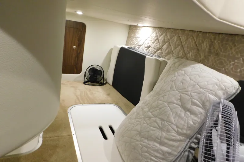 Slide: The Image of 2017 Rinker EX 320 cabin interior with quilted bedding and fan. - 108