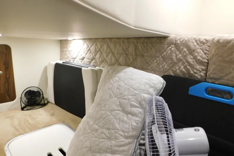 Slide: The Image of 2017 Rinker EX 320 cabin interior with fan, cushions, and quilted wall. - 109