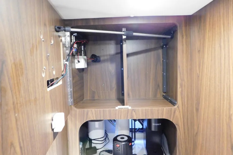 Slide: The Image of 2017 Rinker EX 320 interior cabinet with wiring and Keurig coffee maker. - 111