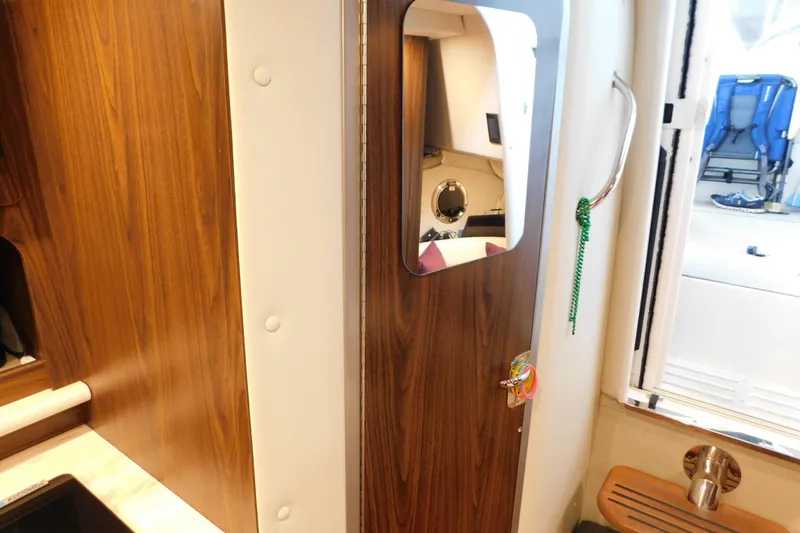 Slide: The Image of 2017 Rinker EX 320 cabin interior with wooden door and mirror. - 112