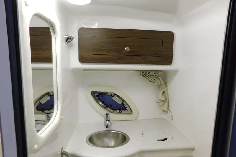 Slide: The Image of 2017 Rinker EX 320 boat bathroom with sink, mirror, and storage cabinet. - 114