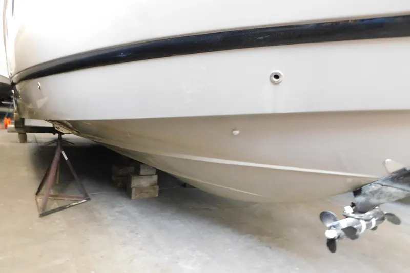 Slide: The Image of 2017 Rinker EX 320 boat hull and propeller in storage. - 12