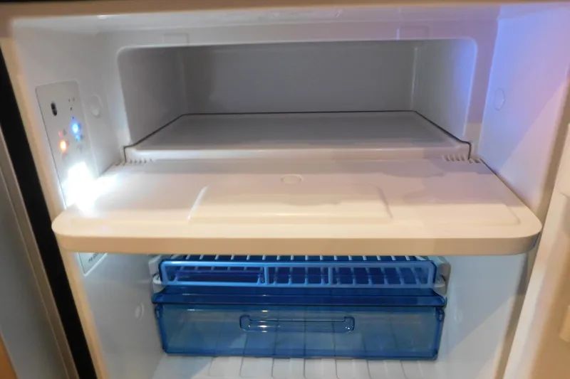 Slide: The Image of Interior view of a 2017 Rinker EX 320 refrigerator, featuring a spacious freezer compartment. - 120