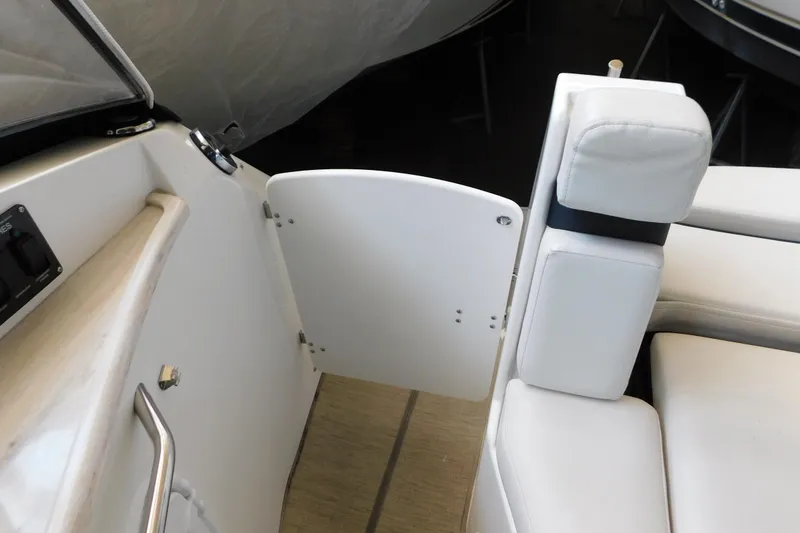 Slide: The Image of 2017 Rinker EX 320 boat interior with white seating and open door. - 34