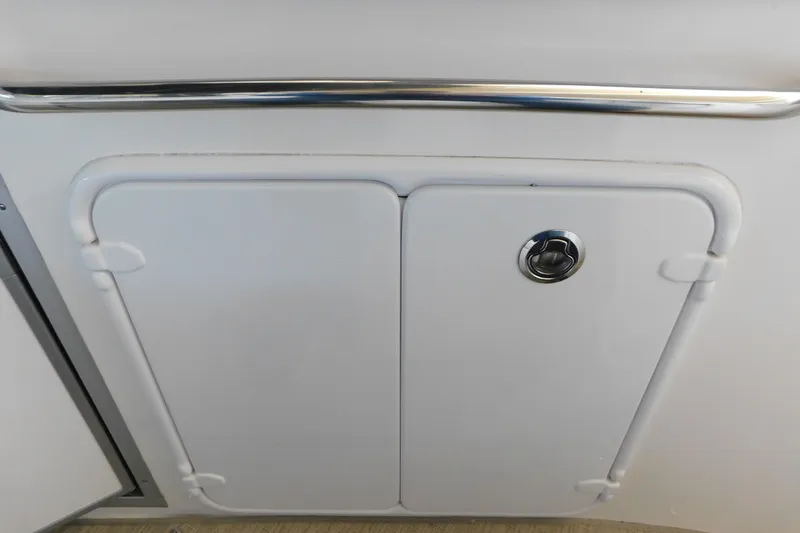 Slide: The Image of 2017 Rinker EX 320 boat storage compartment with chrome handle. - 37