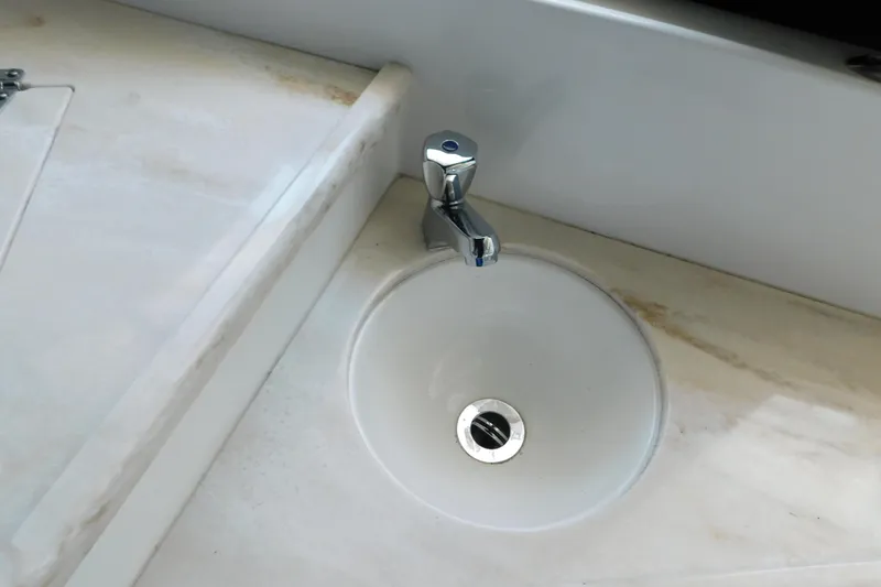 Slide: The Image of 2017 Rinker EX 320 boat sink with chrome faucet on marble countertop. - 41