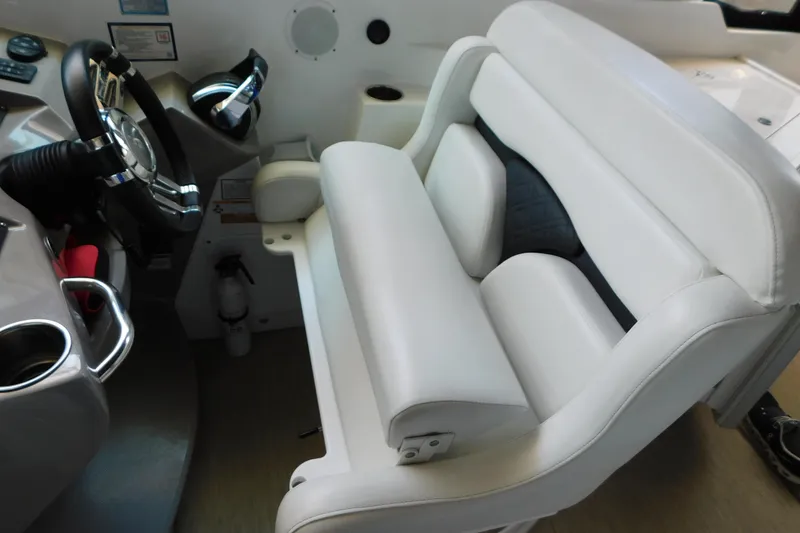Slide: The Image of 2017 Rinker EX 320 boat interior with white captain's seat and steering wheel. - 52