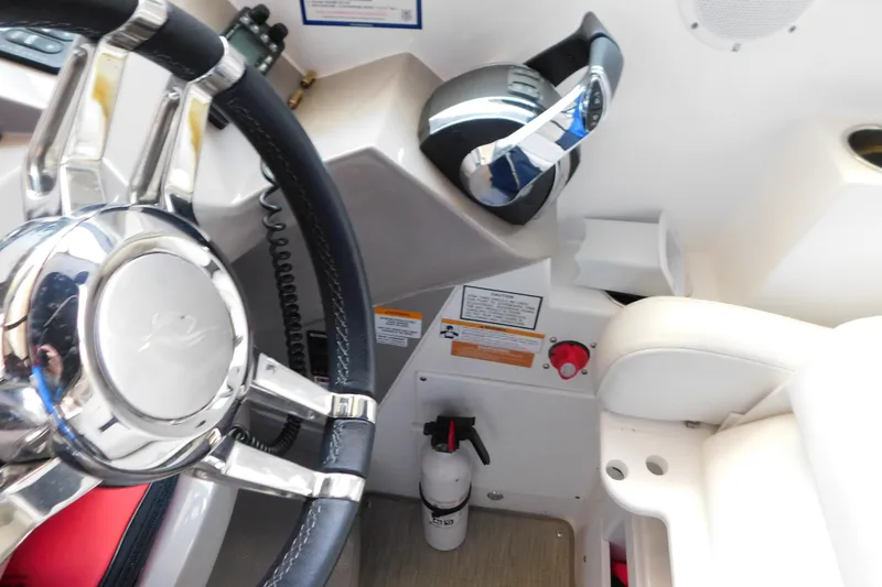 Slide: The Image of 2017 Rinker EX 320 boat cockpit with steering wheel and controls. - 54