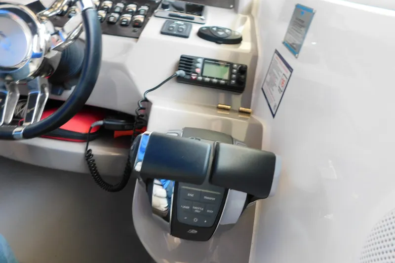 Slide: The Image of Control panel of a 2017 Rinker EX 320 boat with steering wheel and navigation equipment. - 55