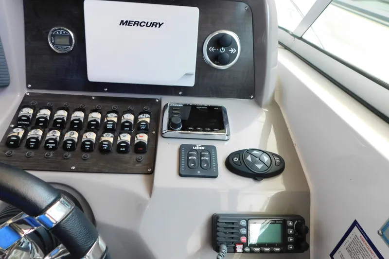 Slide: The Image of Control panel of 2017 Rinker EX 320 boat with Mercury system and various switches. - 56