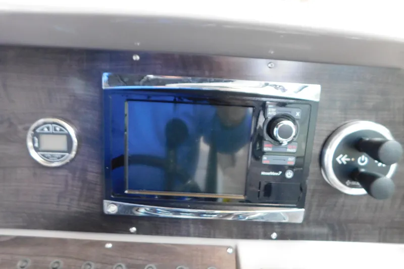 Slide: The Image of Control panel of 2017 Rinker EX 320 boat with navigation and control knobs. - 58