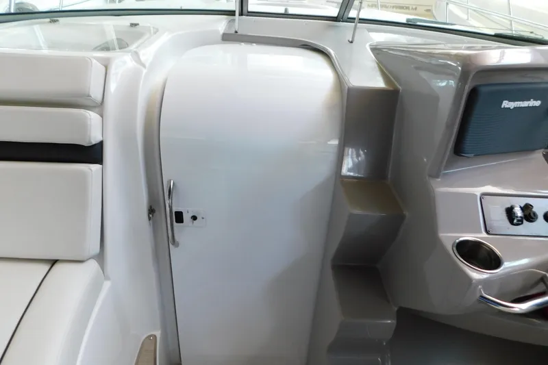 Slide: The Image of 2017 Rinker EX 320 boat interior with white seating and control panel. - 64