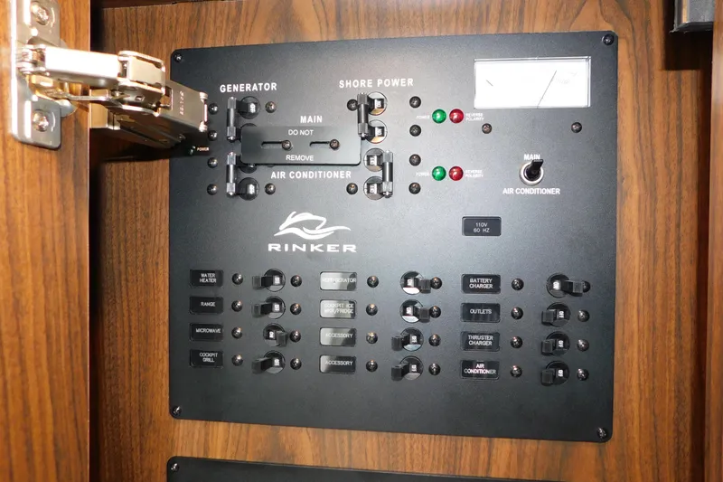 Slide: The Image of Electrical control panel of a 2017 Rinker EX 320 boat, featuring generator and shore power switches. - 67