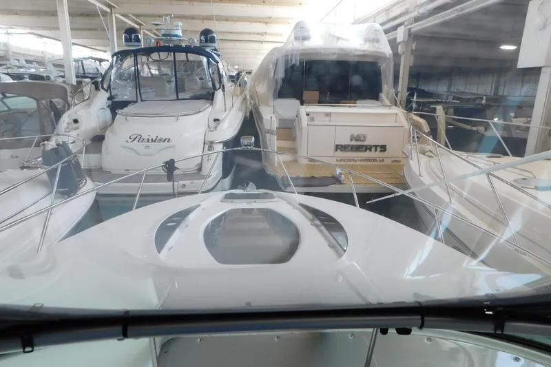 Slide: The Image of 2017 Rinker EX 320 yacht in storage, surrounded by other boats. - 69