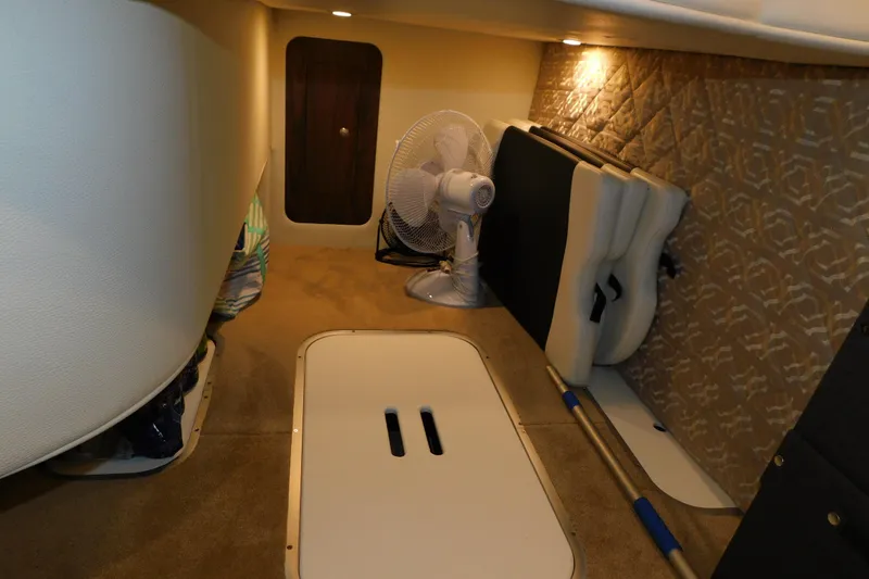 Slide: The Image of 2017 Rinker EX 320 cabin interior with fan and storage compartments. - 71