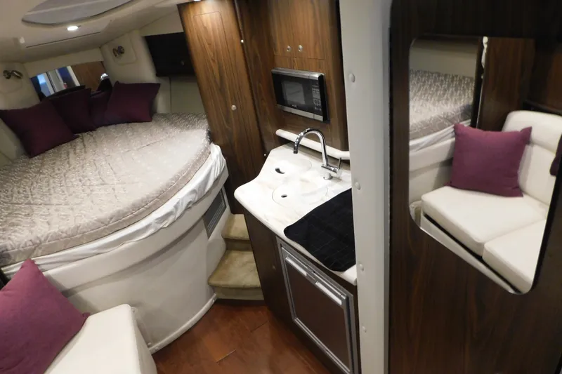 Slide: The Image of 2017 Rinker EX 320 cabin interior with bed, sink, and seating area. - 74