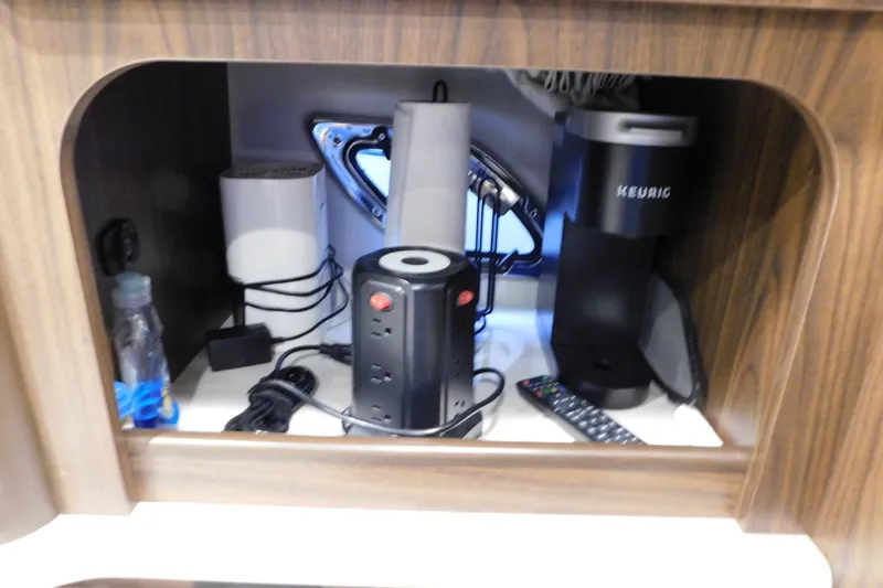 Slide: The Image of 2017 Rinker EX 320 cabin storage with Keurig, iron, and power strip. - 77