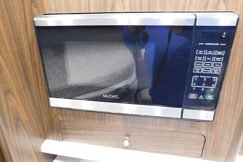 Slide: The Image of Microwave oven in 2017 Rinker EX 320 boat interior, wood paneling background. - 78