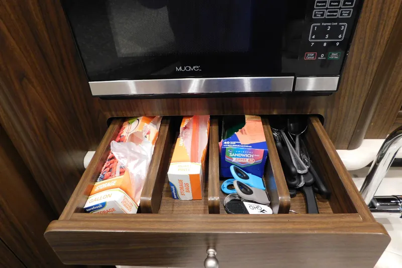 Slide: The Image of Drawer with storage bags and utensils in 2017 Rinker EX 320 boat kitchen. - 83