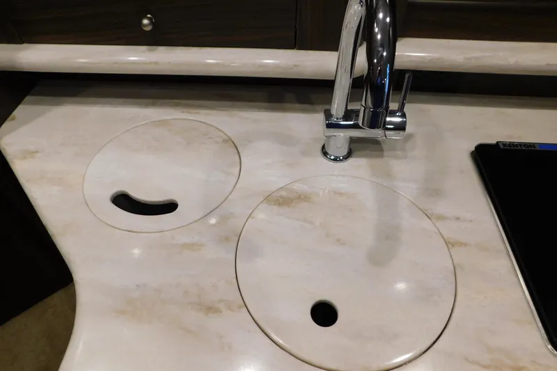 Slide: The Image of 2017 Rinker EX 320 boat kitchen sink with marble countertop and chrome faucet. - 86