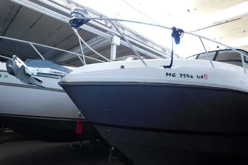 Slide: The Image of 2017 Rinker EX 320 boat in storage, featuring sleek design and visible registration number. - 9