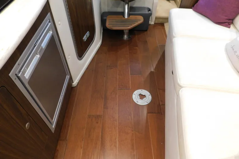 Slide: The Image of 2017 Rinker EX 320 interior with wood flooring and white seating. - 95