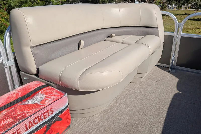 Slide: The Image of 2025 Sun Tracker Party Barge 16 DLX interior with beige seating and life jackets. - 13