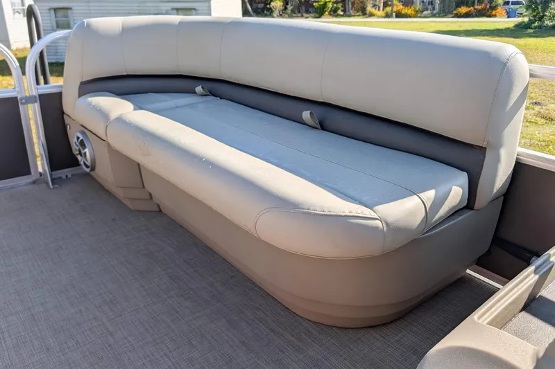 Slide: The Image of 2025 Sun Tracker Party Barge 16 DLX pontoon boat seating, beige upholstery, outdoor setting. - 14