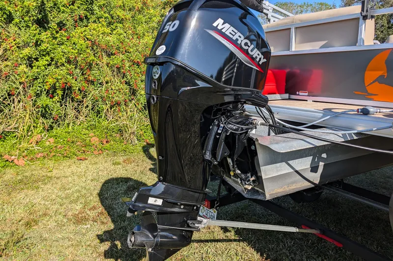 Slide: The Image of 2025 Sun Tracker Party Barge 16 DLX with Mercury outboard motor on grassy area. - 19