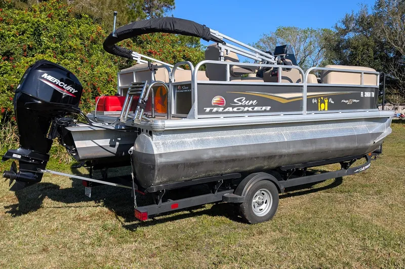 Slide: The Image of 2025 Sun Tracker Party Barge 16 DLX pontoon boat with Mercury outboard motor on trailer. - 3